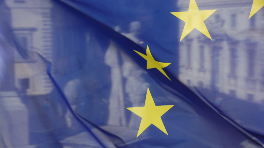 A photo of The EU Flag overlayed on top of statues of Castor and Pollux